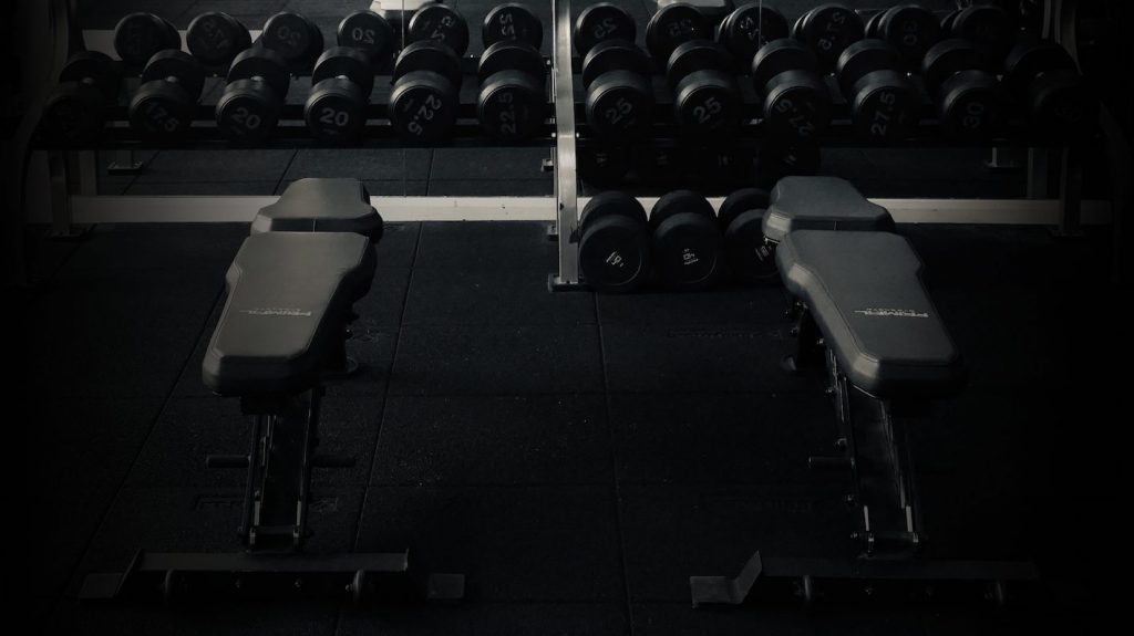 two benches placed side by side in the dumbbells area in a gym in Amersham